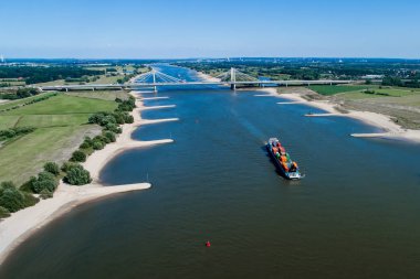 Rhine - Hollanda, 14 Temmuz 2018: Hollanda'nın bir bölgede Ren Nehri geçerken bir konteyner ile bir ticaret gemisine havadan görünümü