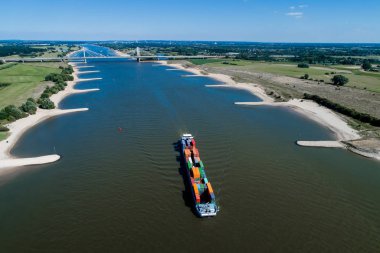 Rhine - Hollanda, 14 Temmuz 2018: Hollanda'nın bir bölgede Ren Nehri geçerken bir konteyner ile bir ticaret gemisine havadan görünümü