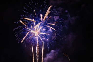 Gece gökyüzünde çeşitli renklerde renkli havai fişekler