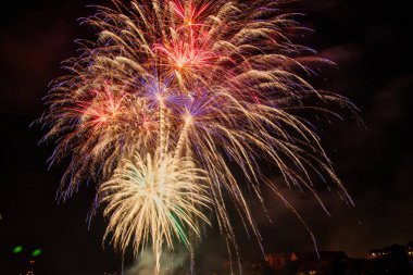 Gece gökyüzünde çeşitli renklerde renkli havai fişekler