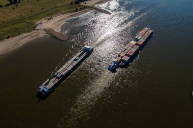 Rhine - Hollanda, 14 Temmuz 2018: Hollanda'nın bir bölgede Ren Nehri geçerken bir konteyner ile bir ticaret gemisine havadan görünümü