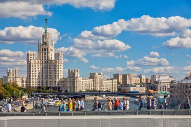 Moscow, Rusya Federasyonu - 13 Ağustos 2018: İnsanlar benzersiz yüzen Köprüsü'nde yeni ve modern Zaryadye parkta yürüyor. Kotelnicheskaya dolgu Binası adam gibi