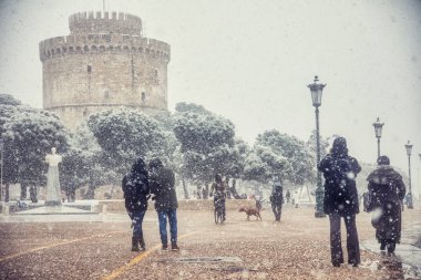 bir kış gününde şehir merkezinde karda yürürken insanlar