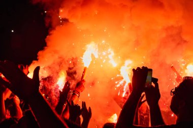 Thessaloniki, Yunanistan - 22 Eylül 2018: Müzik hayranları Selanik şehir açık tiyatro vahşi rock konserinde üzerinde yangın meşale yanmak. Kalabalık Festivali. Tehlikeli yanıcı havai fişek