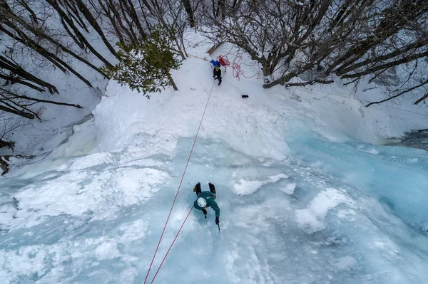 Ice climbing the North Greece, man climbing frozen waterfall.