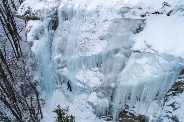 Ice climbing the North Greece, man climbing frozen waterfall.