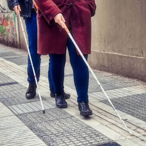 Homem cego e mulher andando na rua usando uma caminhada branca — Fotografia de Stock