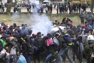 Göçmenler, mülteci kamerasının dışında Yunan isyan polisi ile çatışmalar