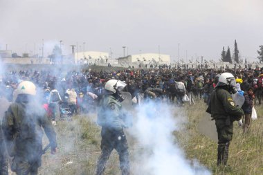 Göçmenler, mülteci kamerasının dışında Yunan isyan polisi ile çatışmalar