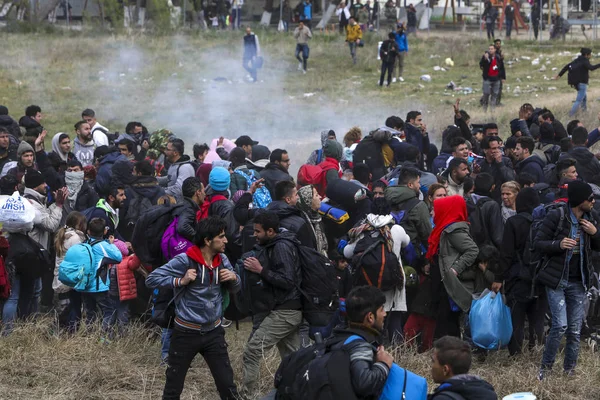 Мигранты сталкиваются с греческой полицией за пределами камеры наблюдения за беженцами — стоковое фото