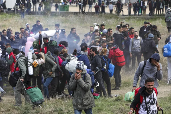 Migrantes se enfrentan con la policía antidisturbios griega fuera de una cámara de refugiados — Foto de Stock