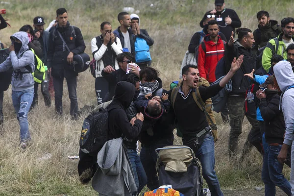 Migrantes se enfrentan con la policía antidisturbios griega fuera de una cámara de refugiados — Foto de Stock