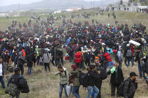 Мигранты сталкиваются с греческой полицией за пределами камеры наблюдения за беженцами
