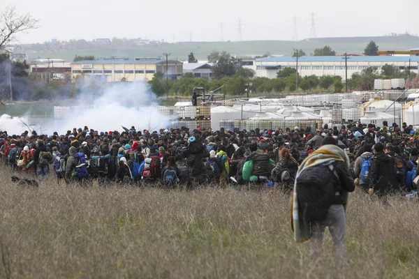 Migrantes se enfrentan con la policía antidisturbios griega fuera de una cámara de refugiados — Foto de Stock