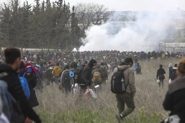 Migrantes se enfrentan con la policía antidisturbios griega fuera de una cámara de refugiados — Foto de Stock