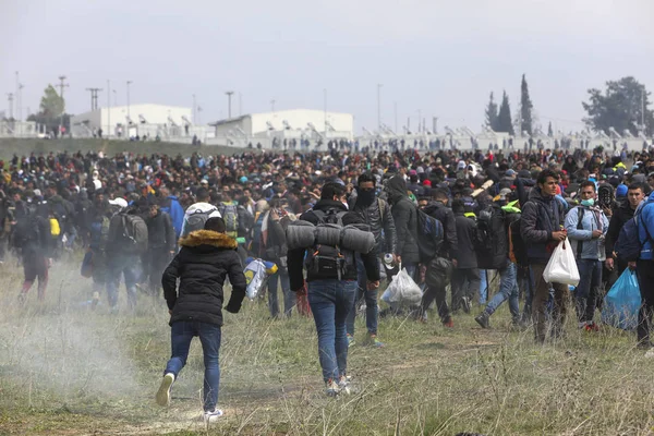 Migrantes se enfrentan con la policía antidisturbios griega fuera de una cámara de refugiados — Foto de Stock