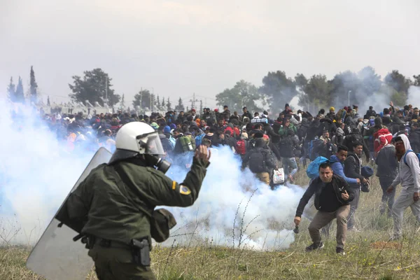 Migrantes se enfrentan con la policía antidisturbios griega fuera de una cámara de refugiados — Foto de Stock