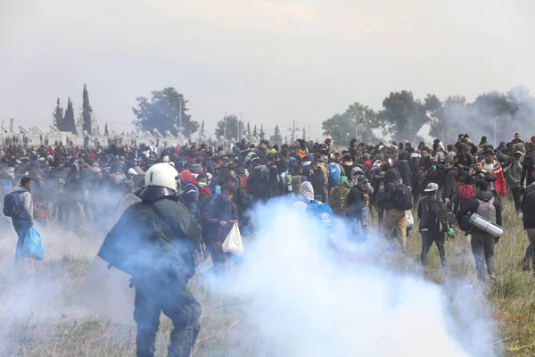 Migrantes se enfrentan con la policía antidisturbios griega fuera de una cámara de refugiados —  Fotos de Stock