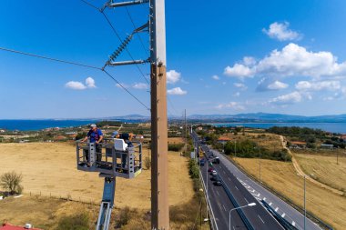 Elektrikçiler yüklemek ve repai elektrik direkleri üzerinde tırmanıyor