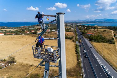 Elektrikçiler yüklemek ve repai elektrik direkleri üzerinde tırmanıyor