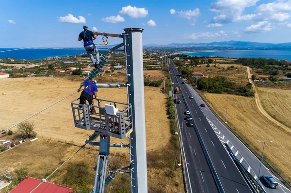 Villanyszerelők a hegymászó az elektromos pólusok telepítése és repai — Stock Fotó