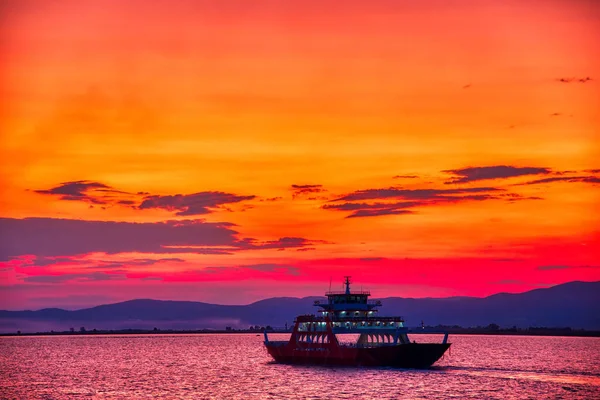 Veerboot naar de zee bij zonsondergang op de achtergrond van bergen a — Stockfoto