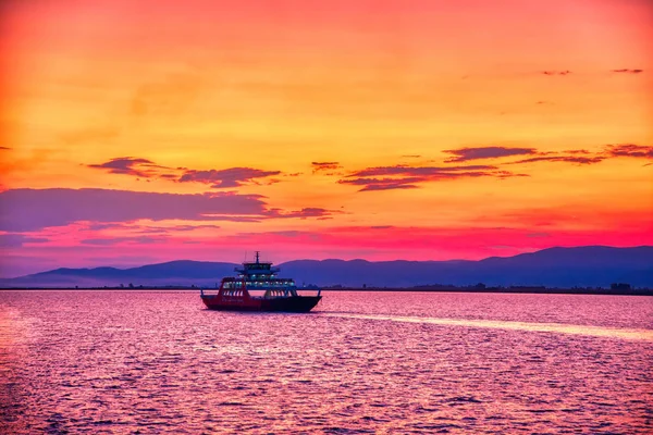 Veerboot naar de zee bij zonsondergang op de achtergrond van bergen a — Stockfoto