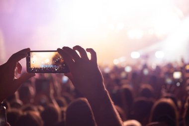 Bir müzik sırasında dokunmatik akıllı telefon ile fotoğraf çekmeye kişi 