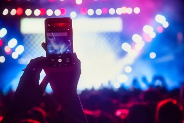Bir müzik sırasında dokunmatik akıllı telefon ile fotoğraf çekmeye kişi 