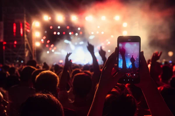 Bir müzik sırasında dokunmatik akıllı telefon ile fotoğraf çekmeye kişi — Stok fotoğraf