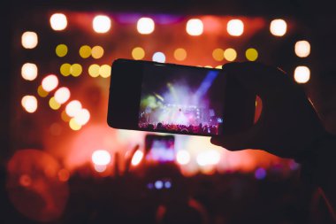 Bir müzik sırasında dokunmatik akıllı telefon ile fotoğraf çekmeye kişi 