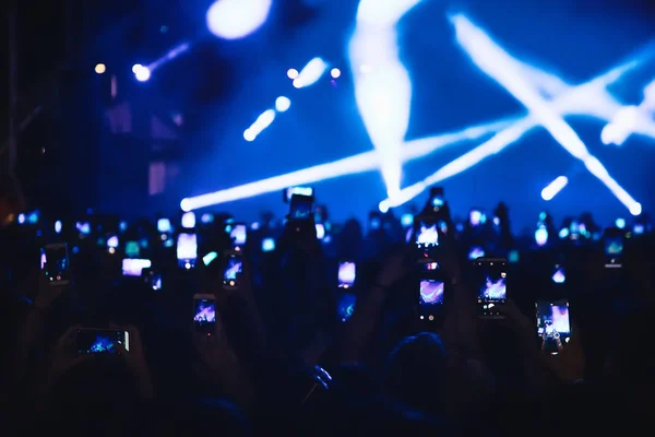 Pessoas tirando fotos com telefone inteligente de toque durante uma música — Fotografia de Stock