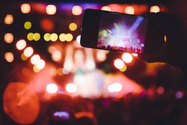 Bir müzik sırasında dokunmatik akıllı telefon ile fotoğraf çekmeye kişi 