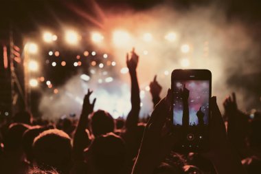 Bir müzik sırasında dokunmatik akıllı telefon ile fotoğraf çekmeye kişi 