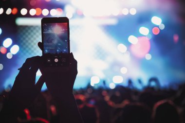 Bir müzik sırasında dokunmatik akıllı telefon ile fotoğraf çekmeye kişi 