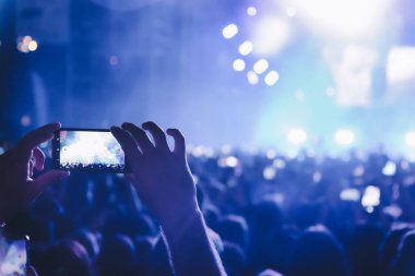 Bir müzik sırasında dokunmatik akıllı telefon ile fotoğraf çekmeye kişi 