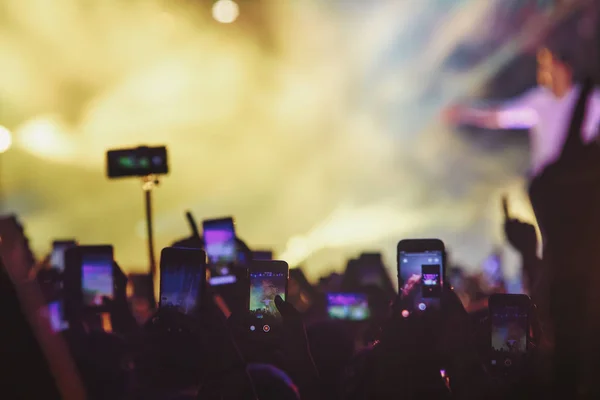 Personas que toman fotografías con un teléfono inteligente táctil durante una música —  Fotos de Stock