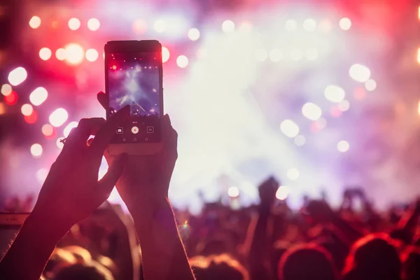 Personas que toman fotografías con un teléfono inteligente táctil durante una música — Foto de Stock