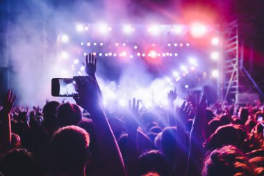 Bir müzik sırasında dokunmatik akıllı telefon ile fotoğraf çekmeye kişi 