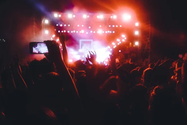 Personas que toman fotografías con un teléfono inteligente táctil durante una música — Foto de Stock