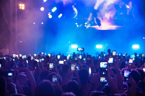 Pessoas tirando fotos com telefone inteligente de toque durante uma música — Fotografia de Stock