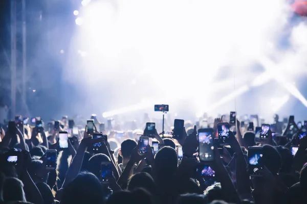 Personas que toman fotografías con un teléfono inteligente táctil durante una música —  Fotos de Stock