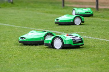Stadyumda yeşil çim üzerinde otomatik robotik çim biçme makinesi