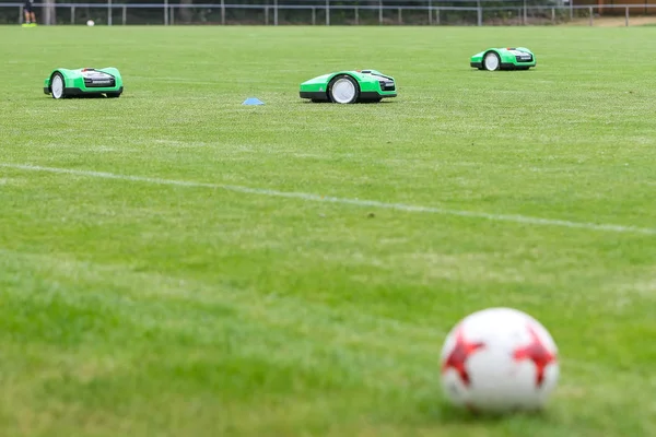 Automatické robotické sekačky na zelené trávě na stadionu — Stock fotografie