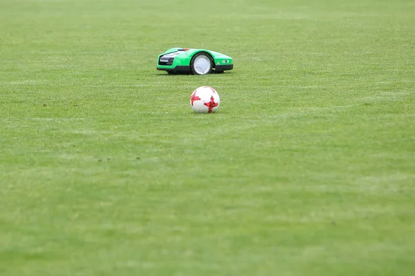 Automatic robotic lawnmower on green grass in the stadium — Stock Photo, Image