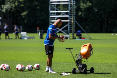 Paok kaleci koçu trai sırasında fırlatma makinesini besliyor.