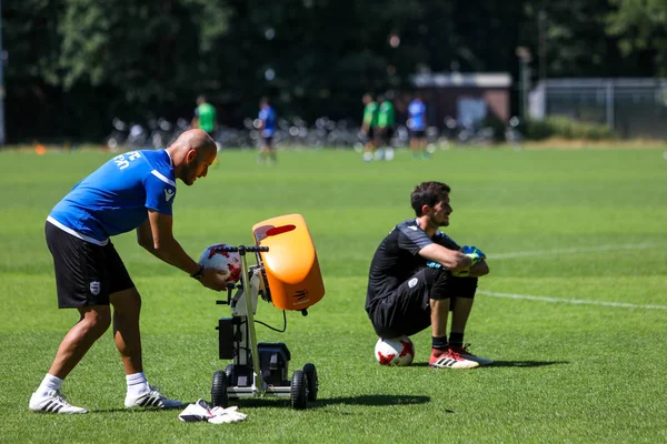 PAOK goalkeeper coach feeds the throwing machine during the trai — ストック写真