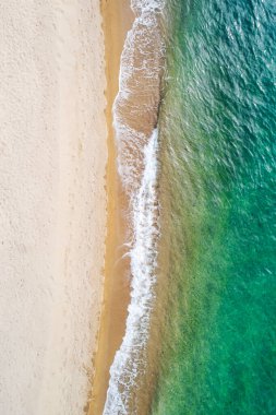 Yunanistan 'ın Chalkidiki kentindeki Sithonia yarımadasındaki Lagomandra plajının havadan görünüşü. Kumsal ve dalgalar yukarıdan görünüyor. Turkuaz su arka planı. Havadan gelen yaz deniz manzarası
