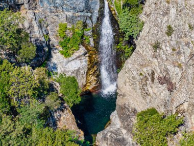 Samothraki, Yunanistan Şelalesi, Fonias Vadisi 'nde engebeli kayalar ve gür yeşilliklerle çevrili berrak bir havuza dökülüyor.