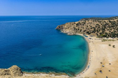Samothraki, Yunanistan Altın kum, turkuaz deniz, kayalık tepeler ve dağınık şemsiyeleriyle Pachia Ammos Plajı 'nın havadan görünüşü
